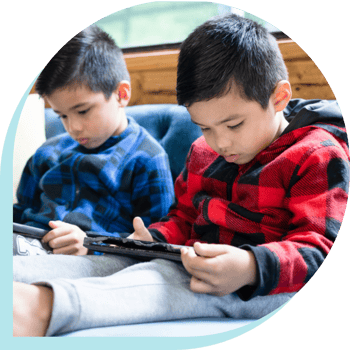 2 young children viewing ipads 